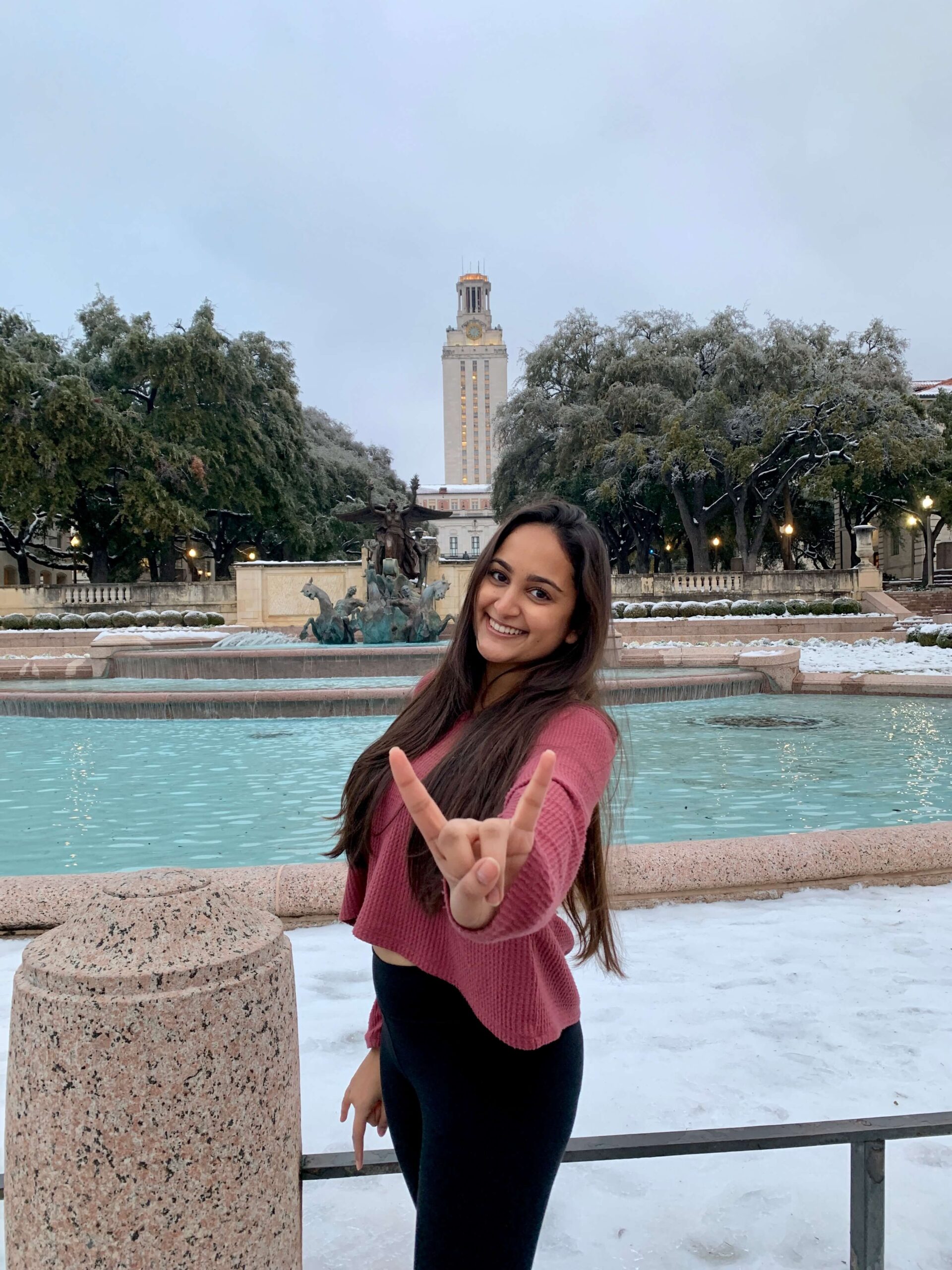 Project Yellow founder giving Hook 'Em Horns hand sign in front of UT tower