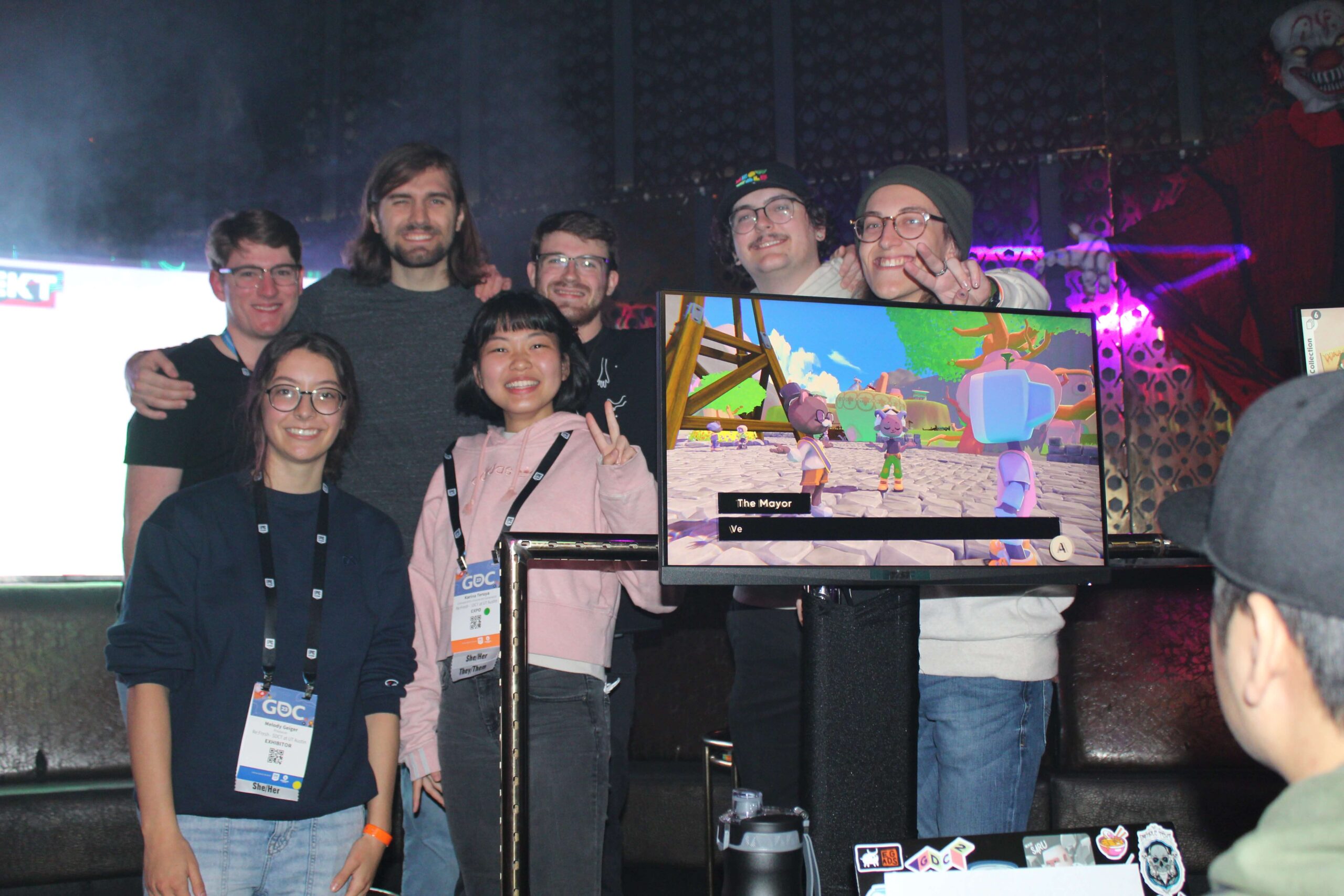 Group of people on stage with a computer monitor